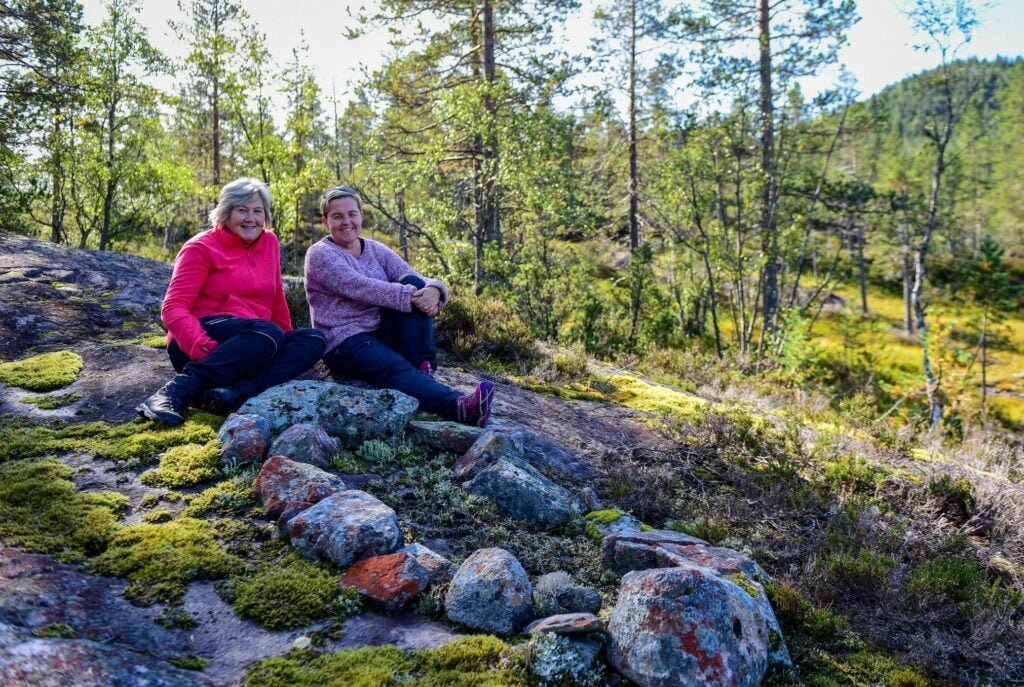 Helga Flateland (t.v.) og Anita Jørstad ved det som truleg er likkvila etter tipp-oldemor deira ved Ratøygard i Bygland. Foto.