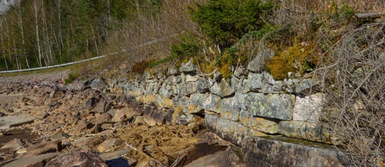 Gamle steinmurar etter Postvegen i vasskanten i Urdviki. Foto.