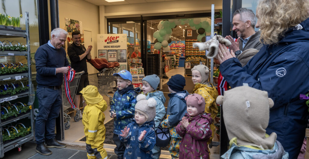 Barn og vaksne foran inngangen til Europris Evje under opninga av butikken. Foto.