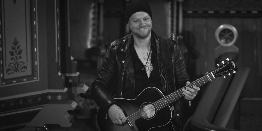 Tom H. Andersen spiller gitar under U2-konserten i Evje kyrkje 29. mai 2022.